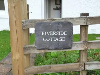 a sign on a wooden fence that reads investigate coffee at Riverside Cottage, Bridge of Balgie, Glenlyon, Perthshire in Bridge of Balgie