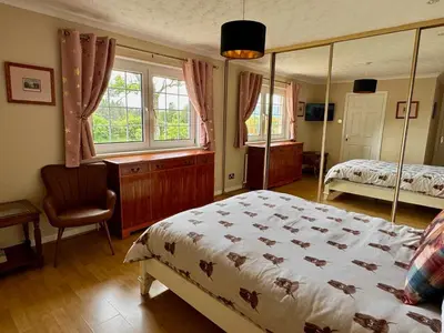 a bedroom with a bed and a chair and windows at FINN VILLAGE 