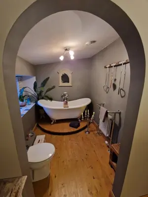 a bathroom with a tub and a toilet and a sink at Fyne Byre Cottage - Barn Conversion with Hot Tub in Cairndow