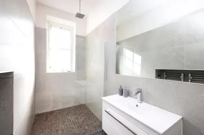 a white bathroom with a sink and a mirror at JOIVY Contemporary Flat in the New Town in Edinburgh