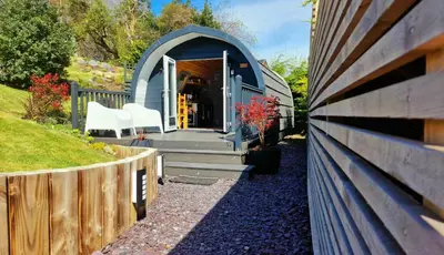 a blue dome house with a wooden fence at Bothan Creag Sobhrag in Ballachulish