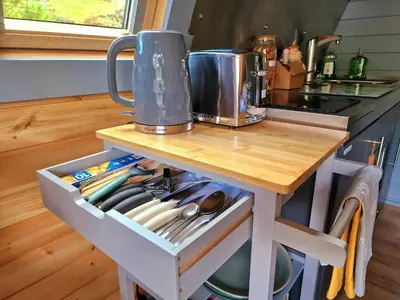 a kitchen counter with a table with utensils on it at Bothan Creag Sobhrag in Ballachulish