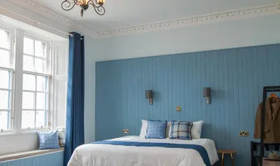 a blue bedroom with a bed with blue walls at Coorie in Dunfermline