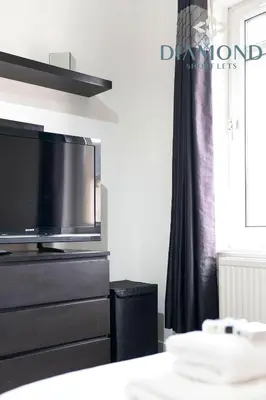 a living room with a flat screen tv on a dresser at Cosy 2 Bed Apt West End Edinburgh FREE PARKING in Edinburgh
