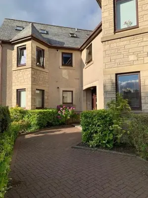 a house with a brick driveway in front of it at Teith court apartment with private parking. in Stirling