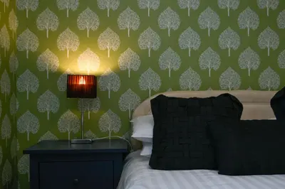 a bedroom with a bed and a green wall at Cologin Farmhouse in Oban