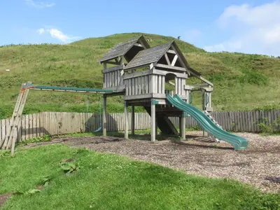 a playground with a slide and a play structure at Cologin Farmhouse in Oban