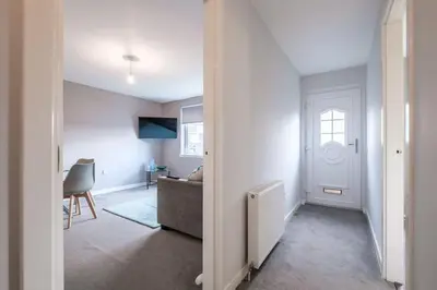 an open hallway with a living room and a door at Monicas Apartment Lovely ground floor 2 bedroom serviced apartment in Coatbridge