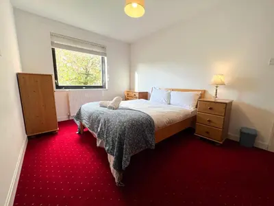 a bedroom with a bed and a red carpet at Anniesland Glasgow 1bd Flat - Free Parking in Glasgow