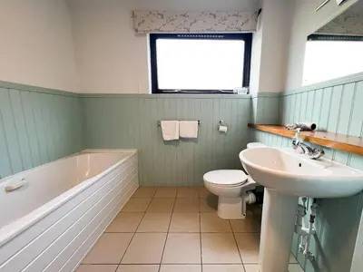 a bathroom with a sink and a tub and a toilet at Anniesland Glasgow 1bd Flat - Free Parking in Glasgow
