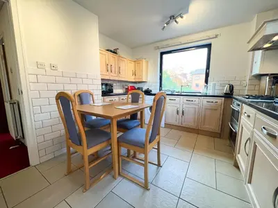 a kitchen with a wooden table and chairs at Anniesland Glasgow 1bd Flat - Free Parking in Glasgow