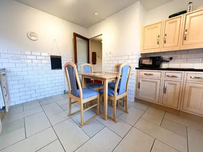 a kitchen with a wooden table and blue chairs at Anniesland Glasgow 1bd Flat - Free Parking in Glasgow