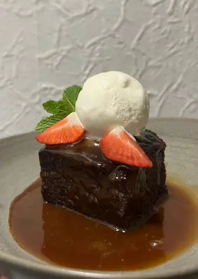 a piece of chocolate cake with ice cream and fruit on top at The Rhu Inn in Rhu