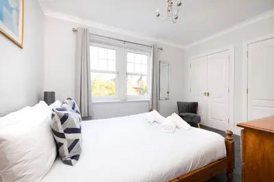 a bedroom with a white bed and a desk at JOIVY Modern Flat with Free Parking in Edinburgh