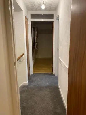 an empty hallway with a hallway leading into a room with a hallway at 3 bedroom home-inverkeithing in Fife