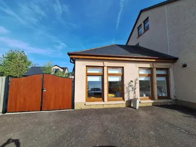 a house with large windows and a wooden fence at Lanarkshire Apartment- Views- Sleeps 4- Balcony in Larkhall