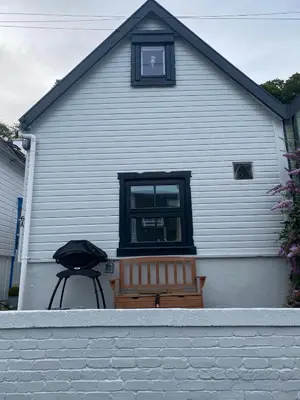 a house with a bench and a grill in front of it at 3 bedroom cosy cottage in Lamlash, Isle Of Arran in Lamlash