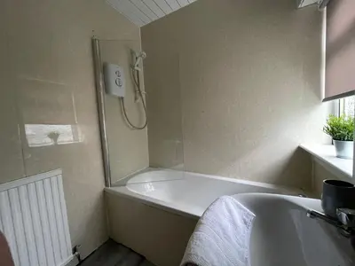 a bathroom with a shower and a bath tub at Cardonald House in Glasgow