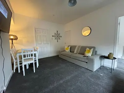 a living room with a couch and a table at Cardonald House in Glasgow