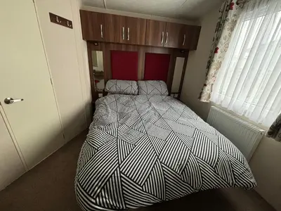 a bedroom with a bed with a black and white comforter at Coyles retreat in Stranraer