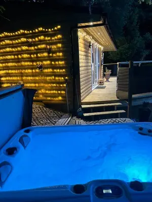 a hot tub in front of a house with lights at Unique Orchard Lodge for couples with hot tub in Strathaven