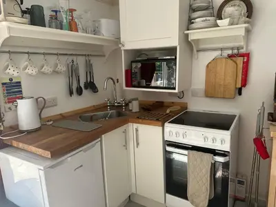 a small kitchen with a sink and a stove at Unique Orchard Lodge for couples with hot tub in Strathaven