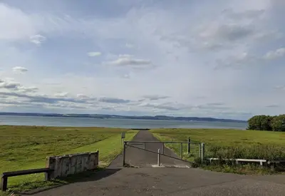 a dirt road leading to a field with a fence at Ferry Gait Apartments in Edinburgh