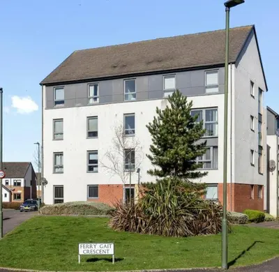 a large white building with a sign in front of it at Ferry Gait Apartments in Edinburgh