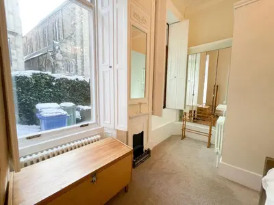 a room with a fireplace and a large window at 1 Bed Character Filled Glasgow Apartment in Glasgow