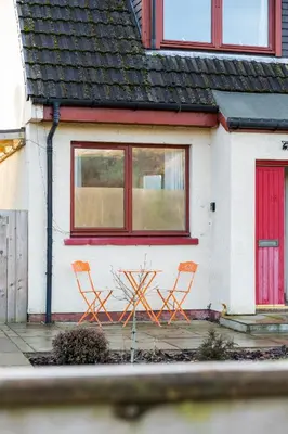 two orange chairs sitting in front of a house at The Nest - small double room nr Glencoe in Ballachulish
