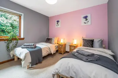 two beds in a room with purple walls at The Keep at Craigiehall in Edinburgh