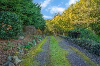 a gravel road in a garden with trees at The Keep at Craigiehall in Edinburgh