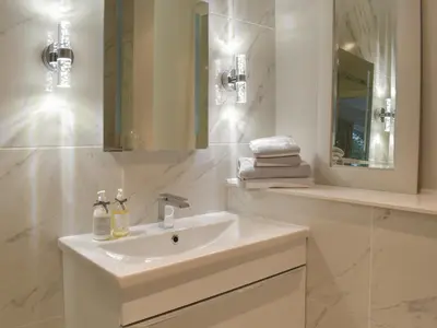 a white bathroom with a sink and a mirror at Whitehouse Studio in Roslin
