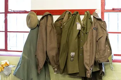 a group of jackets hanging on a wall at Cultybraggan Hut 37 in Comrie