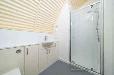 a bathroom with a sink and a shower at Cultybraggan Hut 36 in Mill of Fortune