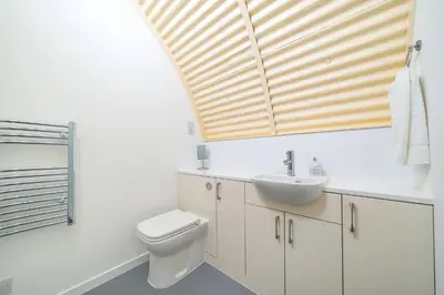a bathroom with a sink and a toilet and a window at Cultybraggan Hut 35 in Comrie