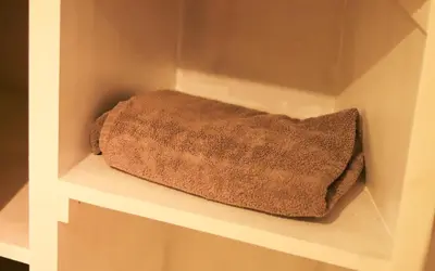 a towel is sitting on a shelf in a closet at 1 Bedrooms Flat in Central Edinburgh Haymarket, Heart of Edinburgh Flat Sleeps 4 , in Edinburgh