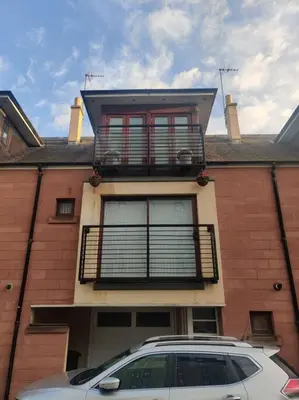 a car parked in front of a house with a balcony at West End & EICC with Parking in Edinburgh