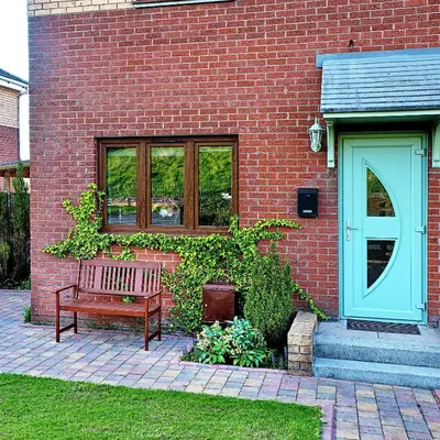 a bench sitting in front of a brick building at A cosy house near the city centre in Glasgow