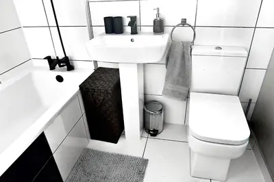 a white bathroom with a sink and a toilet at A cosy house near the city centre in Glasgow