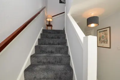 a staircase in a house with a gray carpet at Anchor View in Ardrishaig