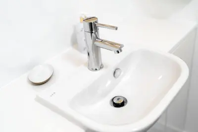 a white bathroom sink with a silver faucet at Cultybraggan Hut 34 in Mill of Fortune