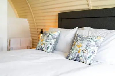 a white bed with two pillows on top of it at Cultybraggan Hut 34 in Mill of Fortune