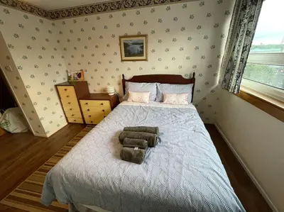 a bedroom with a bed with a chair on it at West End Hidden Gem - Modern 2-Bedroom Apartment with residents patio in Anniesland