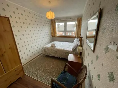 a small bedroom with a bed and a window at West End Hidden Gem - Modern 2-Bedroom Apartment with residents patio in Anniesland