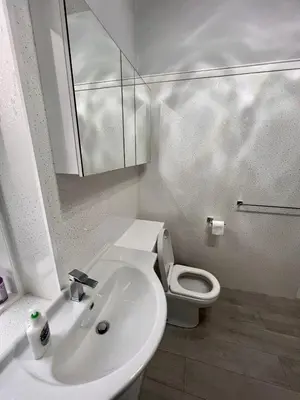 a white bathroom with a sink and a toilet at Anchorage, a lovely 2nd floor one bedroom apartment with fabulous seaviews in Largs
