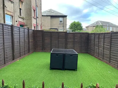 a backyard with a fence and a green lawn at Nelson st (MAYBOLE) in Largs