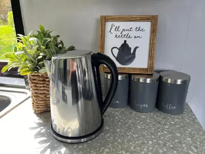 a coffee pot sitting on a counter next to three trash cans at Amazing Loch Views in Kilmun