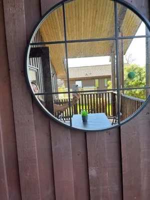 a mirror on a wall with a table and a person at Amazing Loch Views in Kilmun