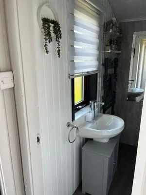 a white bathroom with a sink and a mirror at Amazing Loch Views in Kilmun